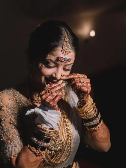 A playful, candid moment captured during the wedding. The bride's joy is infectious, and her traditional look, complete with intricate jewellery, is simply stunning.