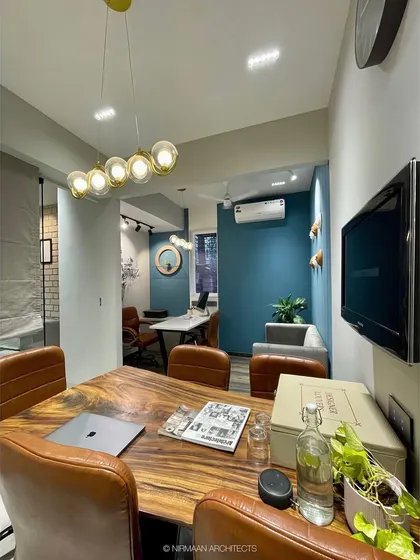 The conference area in our studio, with a live-edge wood table and a gallery wall of our projects. This is where we sit down with clients for our *bharpur meetings* to dive deep into their vision.