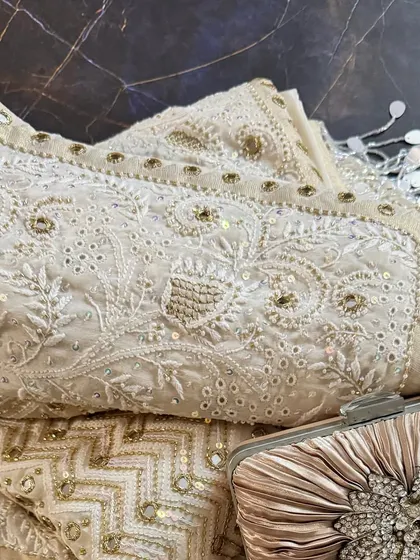 A close-up of the folded saree with a clutch, perfect for appreciating the intricate details.