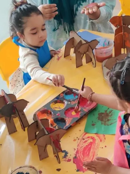A child carefully chooses her colors, fully engaged in the process of painting her elephant. We encourage focus and individual expression in every activity.