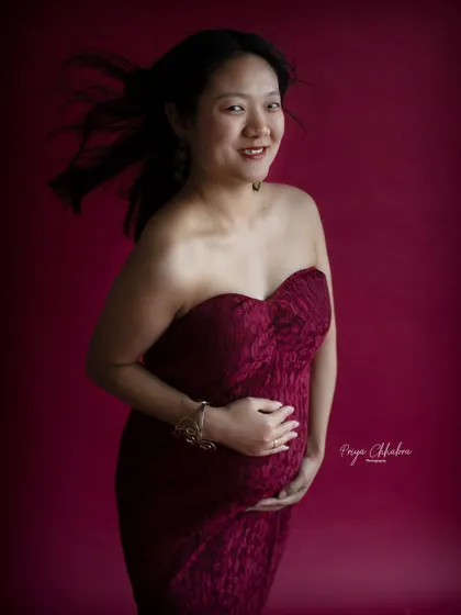 A classic and joyful solo maternity portrait. The simple act of cradling the bump combined with a happy smile creates a timeless and heartwarming image.