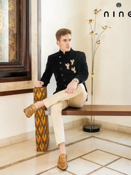 For weddings and receptions, we create Indo-Western outfits that stand out. This Angrakha-style Bandhgala in rich velvet is detailed with antique gold embroidered birds, blending heritage with contemporary elegance.
