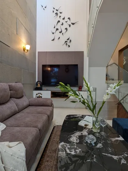Even in compact areas, we believe in making a statement. This double-height living room uses a textured stone wall and a custom 3D bird sculpture to draw the eye upward, creating a feeling of spaciousness and unique character.