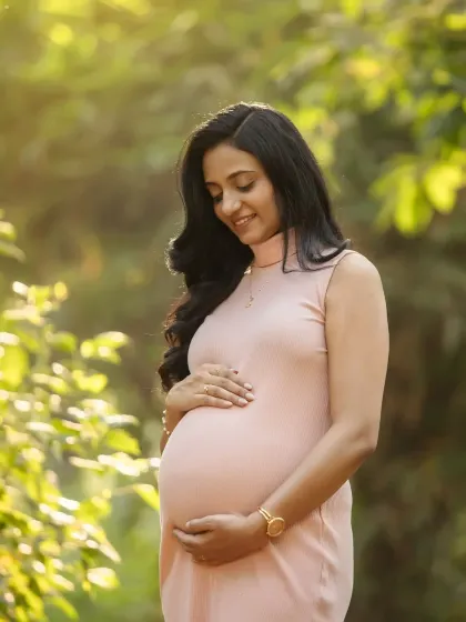 A beautiful solo portrait, cradling your bump in the soft sunlight. You look so peaceful and radiant in this natural setting.