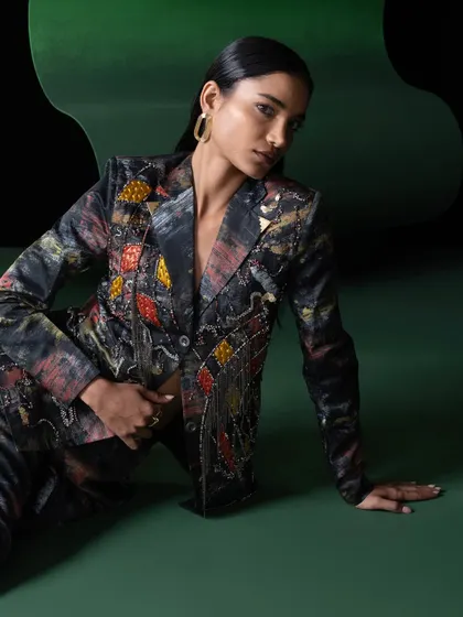 Another look from the Advait campaign, this time a full suit with intricate embellishments. The seated pose creates an elegant and grounded feel, contrasting with the vibrant energy of the other shots.