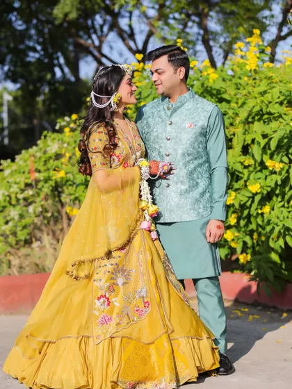 A happy, candid shot of the couple during their Haldi ceremony. Their coordinated outfits and genuine smiles reflect the joy and love of the occasion.