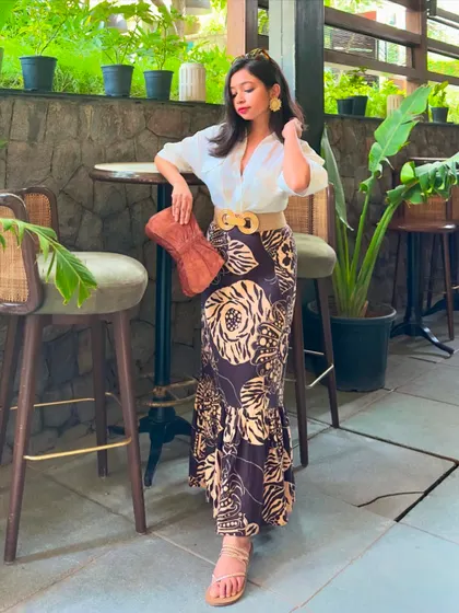 A summer outfit with an 'old money' aesthetic. I've paired a printed linen fishtail skirt with a classic white shirt, a jute belt, and a leather purse for a look that's perfect for a vacation or a weekend brunch.