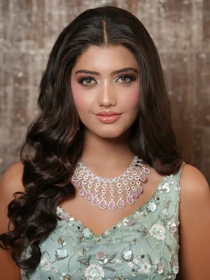 A close-up of the soft glam makeup. The focus is on radiant skin, subtly defined eyes, and glossy lips, creating a fresh and youthful look perfect for an evening event.