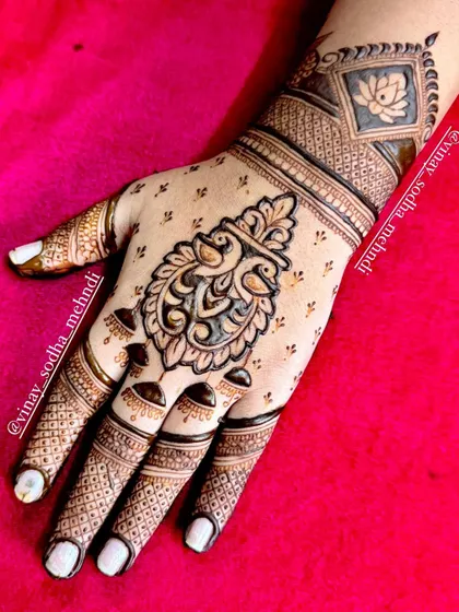 A chic and modern back-of-hand design with a hanging peacock motif. The fingers are minimally decorated for a contemporary feel.