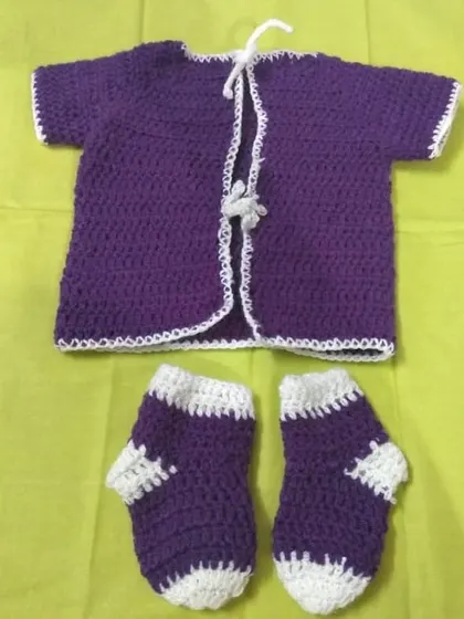 This adorable baby set includes a purple short-sleeved cardigan with a white trim and tie closure, paired with matching purple and white socks.
