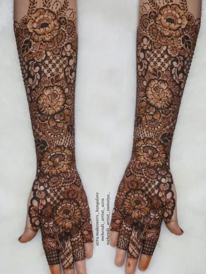 A beautiful Arabic-inspired bridal design with full arm coverage, featuring bold flowers and delicate net patterns.