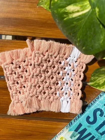 A detailed shot of the pink and white square macrame coaster. The pop of white adds a clean, fresh accent to the design.