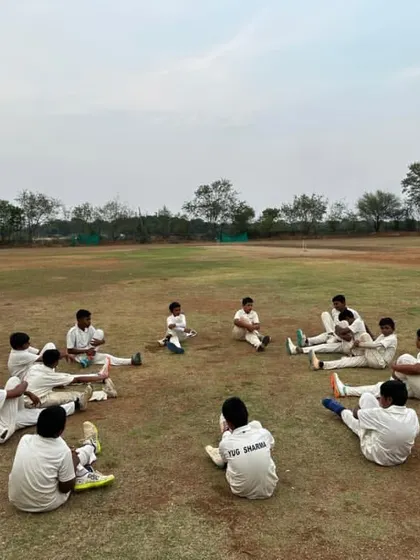 Players stretching in a circle on the field in Hyderabad, an essential pre-match routine.