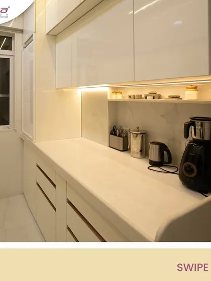 A pristine all-white kitchen with high-gloss cabinets and a marble-finish backsplash. The warm under-cabinet lighting prevents the space from feeling cold and adds a touch of elegance.