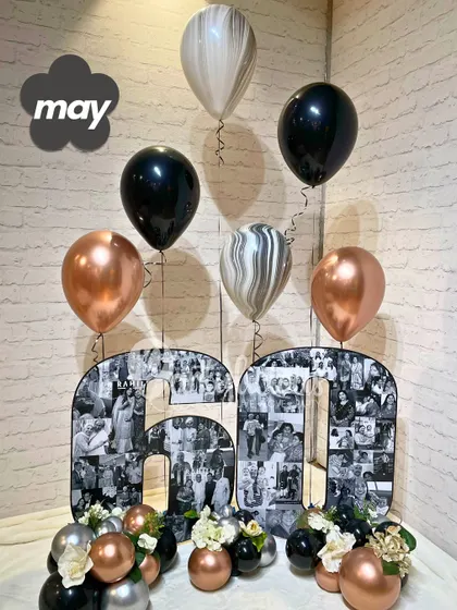 A sophisticated 60th birthday setup featuring custom photo collage numbers and a classic black, silver, and rose gold balloon bouquet.