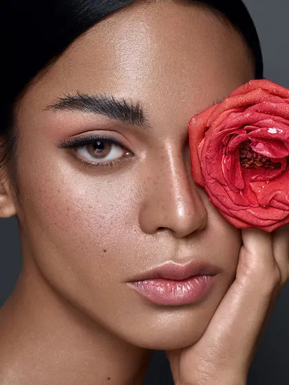 In this version, the rose covers one eye, creating an artistic and slightly mysterious composition. It draws attention to the model's real skin texture and the soft, natural makeup.