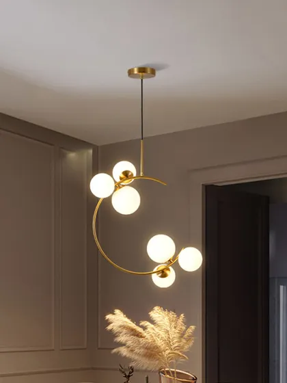 A modern hanging light with a unique crescent shape and globe bulbs. This artistic piece is perfect for adding a touch of contemporary style to a bedroom or reading nook.
