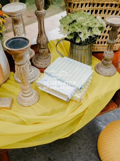 A charming detail shot of a tabletop with wooden candle stands and decorative books, adding to the event's relaxed, homey vibe.