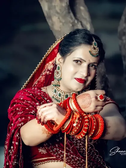 The vibrant red of a bridal lehenga stands out in this outdoor portrait. I focus on capturing the bride's confidence and grace, using lighting that makes the rich colors and intricate details of her wedding attire pop.