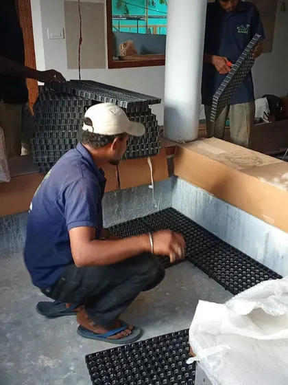 The technical side of indoor gardens. My team is seen installing drainage cells at the base of a large, built-in planter bed to ensure proper water management and plant health.