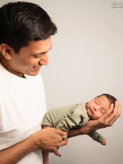 A father's hands, a baby's peaceful sleep. This portrait captures the gentle strength and tenderness of a new dad holding his entire world.