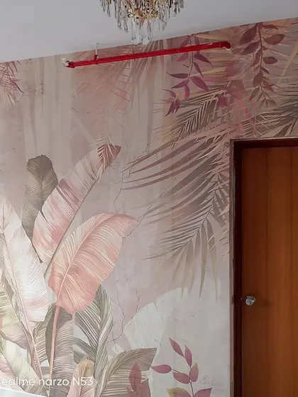 Another view of a similar pastel tropical leaf mural, showing its placement next to a door.