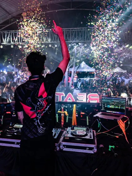 Pointing to the sky during a confetti drop. A perfect shot capturing the scale and excitement of closing a major college music festival.