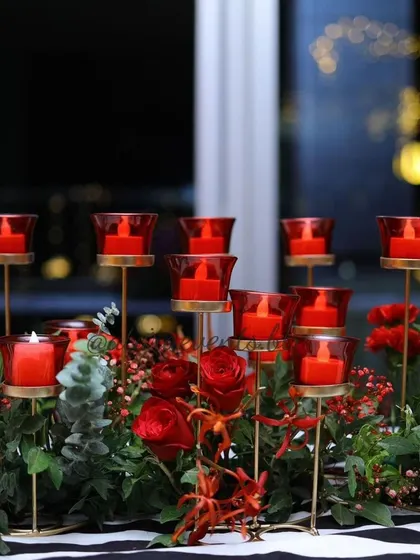 A close-up of the candlelit centerpiece for a 40th birthday. The warm glow of the red candles creates an intimate and celebratory atmosphere, perfect for an evening event.