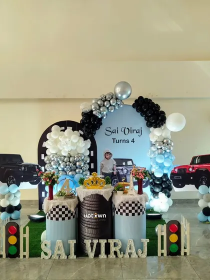 I create unique, personalized themes for birthdays, like this exciting Thar jeep setup for a 4th birthday. It includes custom vehicle cutouts, a tire-themed pedestal, and a color-coordinated balloon arch for any young car enthusiast.