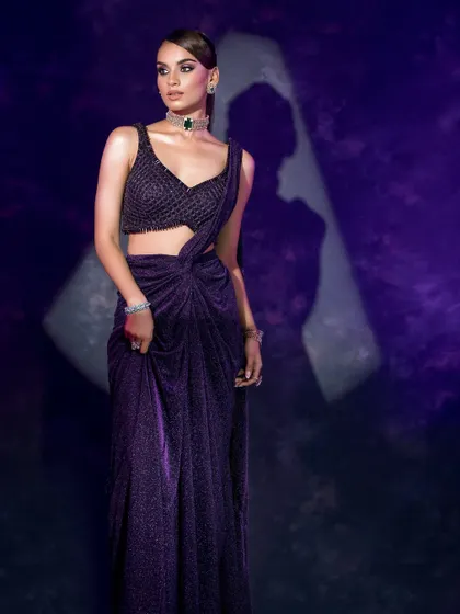 This image plays with shadow and light to create a dynamic composition, highlighting the shimmer and drape of the contemporary saree.
