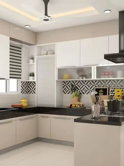 A peninsula with a black countertop creates a defined breakfast bar in this kitchen. The bold, geometric backsplash adds a strong design element that contrasts with the neutral cabinets.