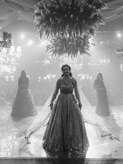 A dramatic black and white shot of the bride's powerful Sangeet performance. We create stages and lighting designs that make our clients feel like the stars of their own show.