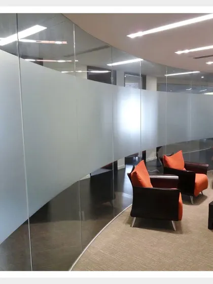 A simple yet elegant plain frosted film applied to a curved glass wall in an office waiting area. It provides a clean, unobtrusive barrier that ensures privacy without making the space feel closed off.