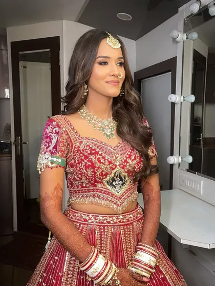A beautiful mirror shot of my bride Ranchi. Her makeup features classic kohl-rimmed eyes and a nude lip, a timeless combination that looks stunning with her red bridal lehenga.