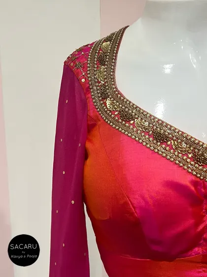 A close-up of the elaborate hand embroidery on a pink blouse, featuring antique gold sequins and beadwork.