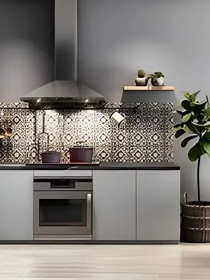 A contemporary kitchen design with grey cabinets and a patterned tile backsplash. A small dining nook is integrated into the space, making it a cozy spot for casual meals.