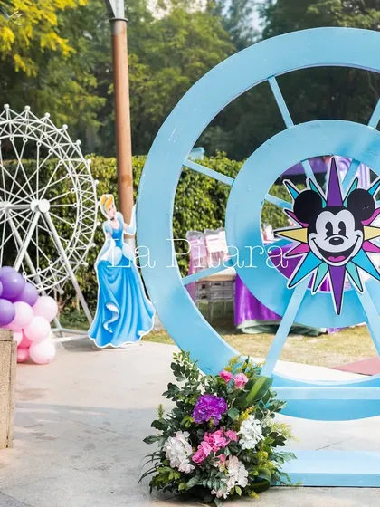 A large, blue Mickey-themed Ferris wheel prop, adding a fun, amusement park vibe to the Disneyland event.