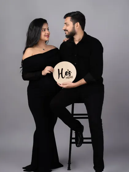 "He's here." A lovely post-birth announcement photo, continuing the story from the maternity session with the couple dressed in black.