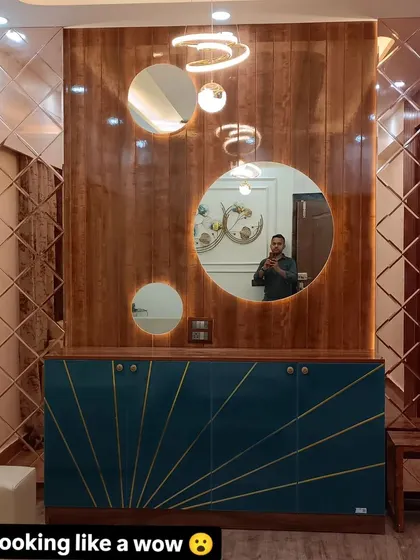 A close-up of the custom-designed crockery unit. The sunburst pattern on the shutters is made with golden metal strips, and the round mirrors add a touch of glamour.