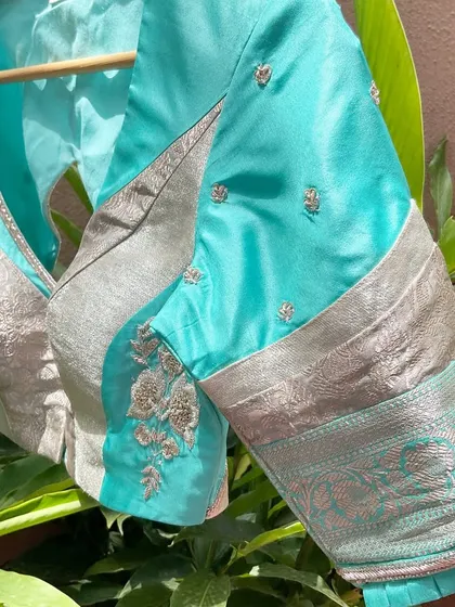 A side view of our turquoise and silver patchwork blouse, showing how we've combined different brocade panels with minimal, delicate embroidery.