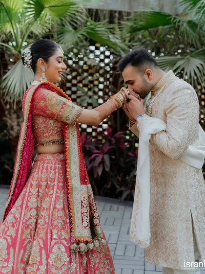 The groom gently kisses his bride's hand, a timeless gesture of love and respect captured beautifully.