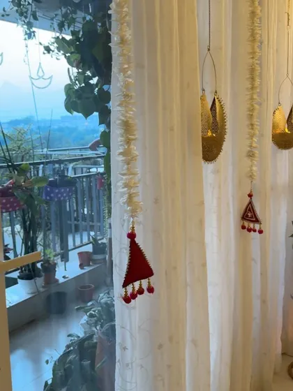 The view from my living room to the balcony during Diwali. The hanging decorations on the curtains add a delicate, festive touch.