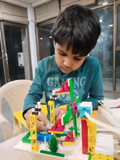 A student carefully constructs his LEGO project, a fun park complete with a Ferris wheel. My classes encourage attention to detail and creative problem-solving.