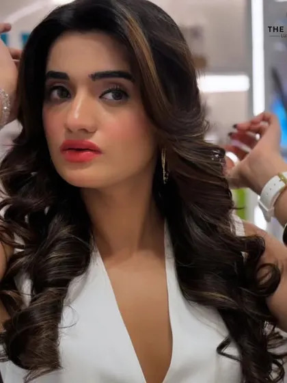 A close-up on the details of this glamorous look. The hair is perfectly styled, and the makeup enhances her natural beauty, creating a confident and fabulous result.