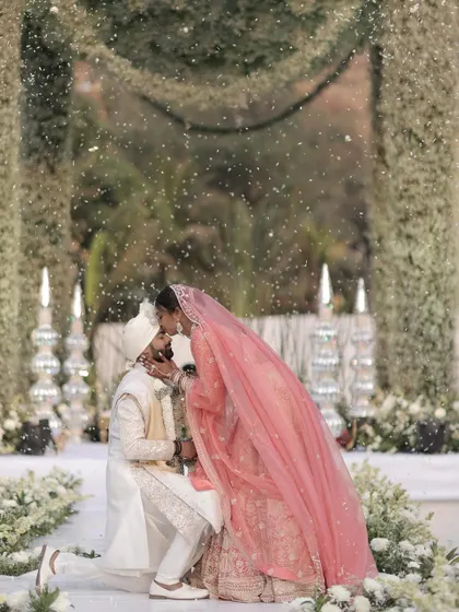 A sweet kiss seals the promise amidst a magical shower of petals. We work with our photo and video crews to capture these fleeting, emotional moments during the Varmala ceremony.