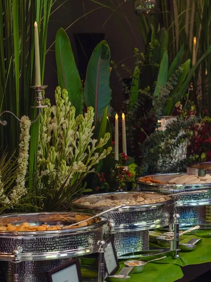 Another angle of the elegant buffet setup, highlighting the silver candelabras and lush greenery that create a sophisticated and timeless look for a large dinner party.