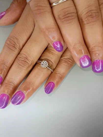 A full view of the vibrant purple and pink ombre nails.