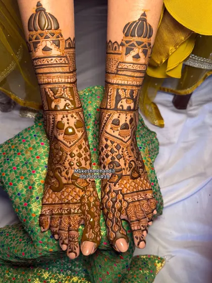This bridal foot design features jhumkas (earrings) and elephants, with a beautiful palace design on the leg. It's a unique and creative style.