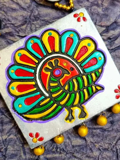A close-up of the square block-printed peacock pendant, showing the fine details of the print. This demonstrates the quality and clarity of the motifs I use.