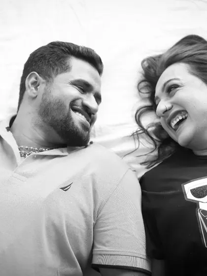 A beautiful black and white photo capturing a moment of shared laughter. This overhead shot from their pre-wedding session is natural and full of happiness.